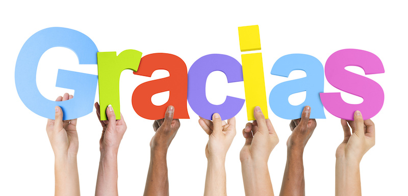 Hands holding the word Thank you in Spanish