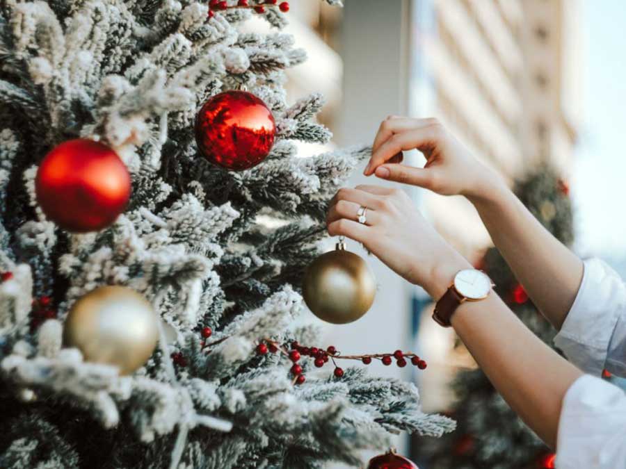person decorating the christmas tree