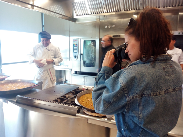 Dénia, destination to study Spanish and eat well Student taking pictures while cooking a rice to band in the CDT