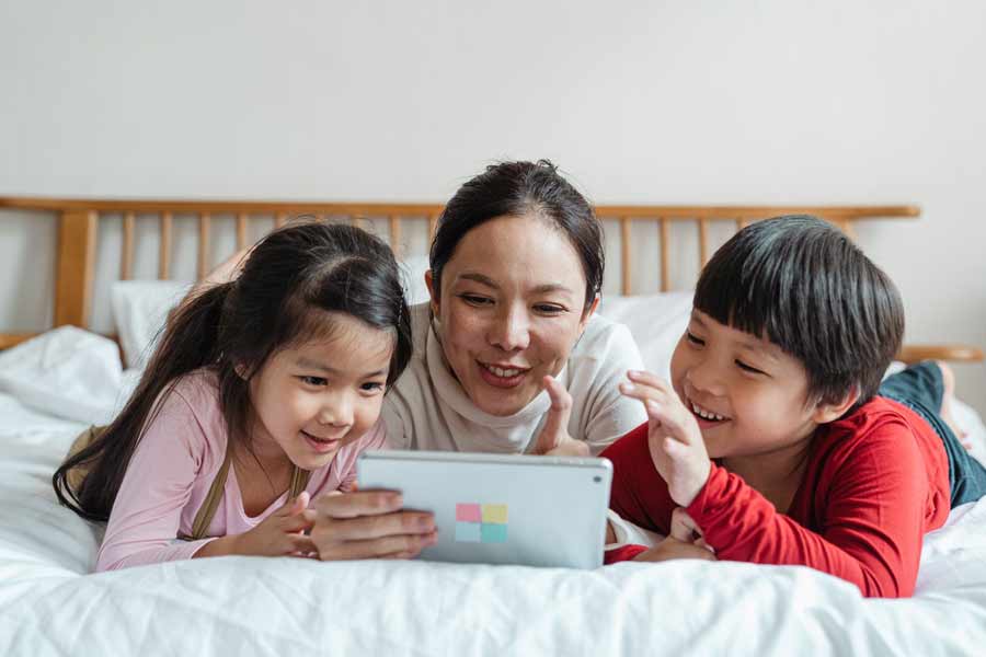Mutter mit ihren beiden Kindern nutzt Apps, um Spanisch für Kinder zu lernen
