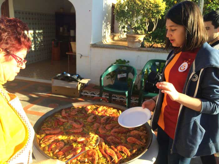 Gruppo scolastico in viaggio studio mangiando paella in Spagna