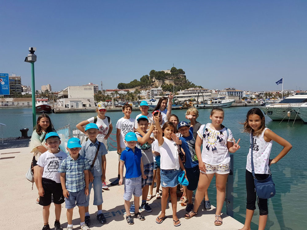 Spaanse cursuskinderen poseren voor een groepsfoto in de haven van Denia