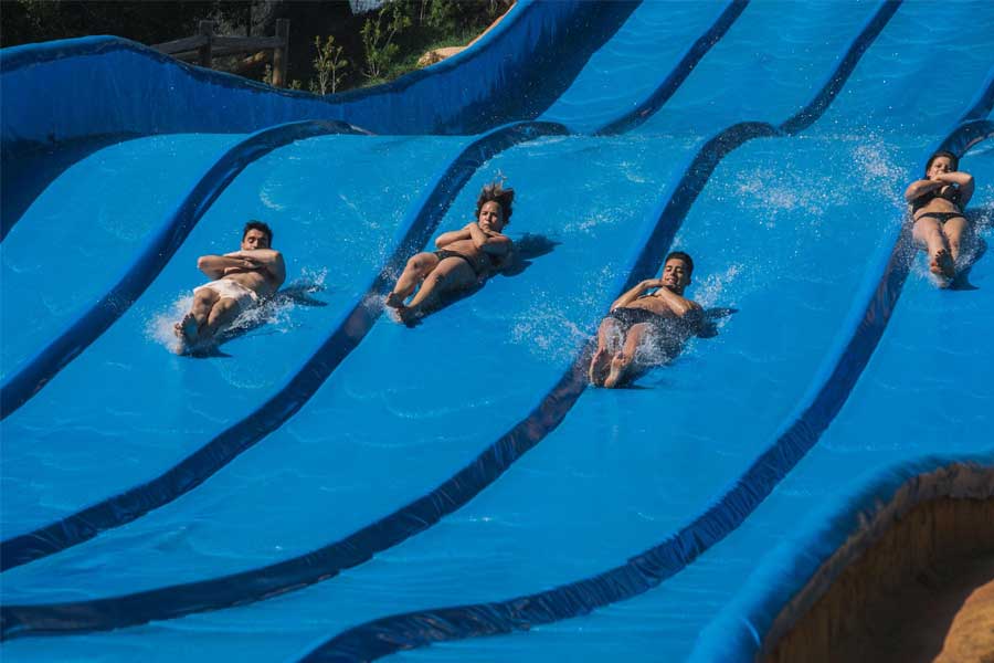 Students of a school group jumping off a slide in Aqualandia, in Spain